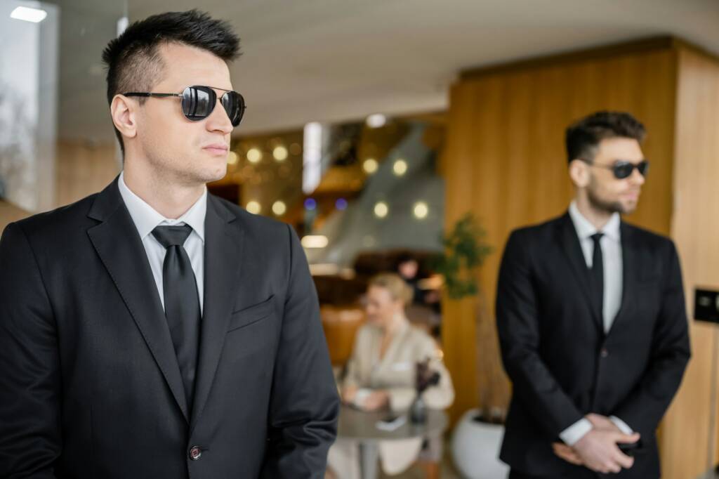 private security, personal safety service, handsome bodyguards in formal wear and sunglasses