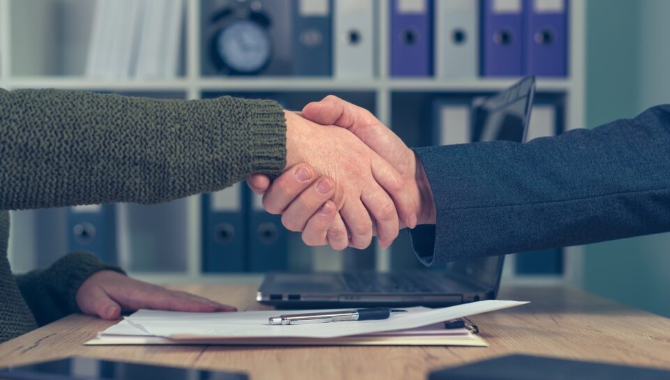 Hombre y mujer se dan la mano tras un acuerdo comercial