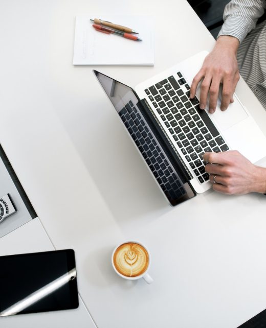 person using laptop on white wooden table